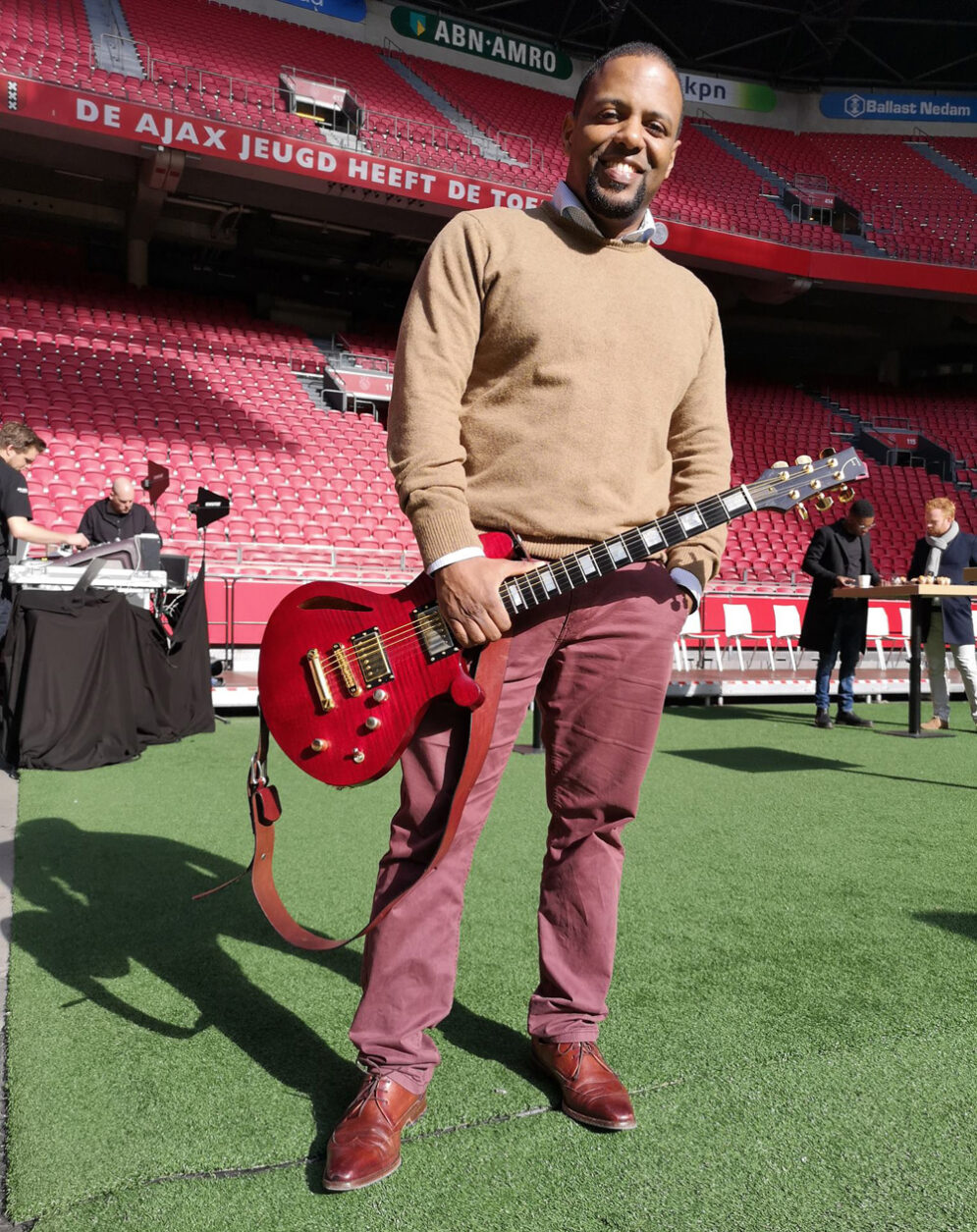 Orville Breeveld met zijn rode Fern's Guitars Custom elektrische gitaar in het Ajax stadion in Amsterdam.